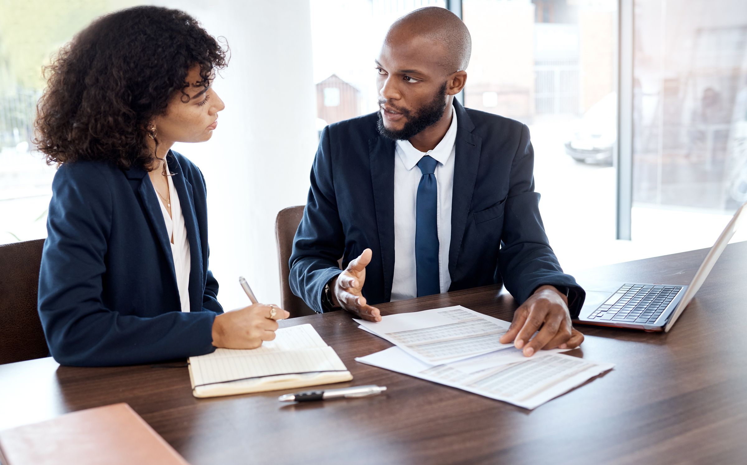 A lawyer and a client going through documents at a meeting table