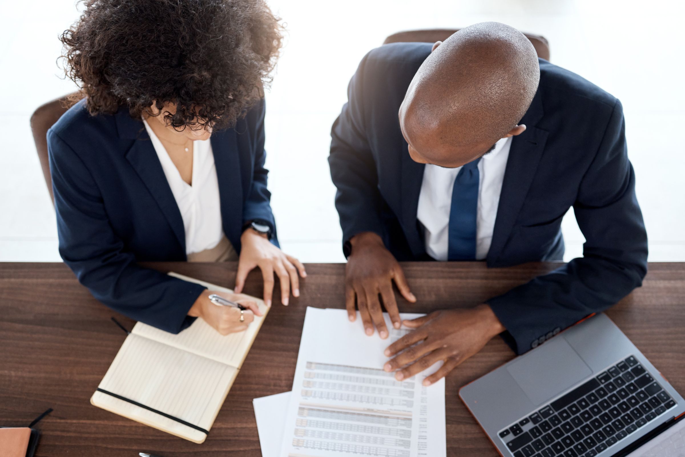 Two lawyers working through a contract at a desk, seen from above