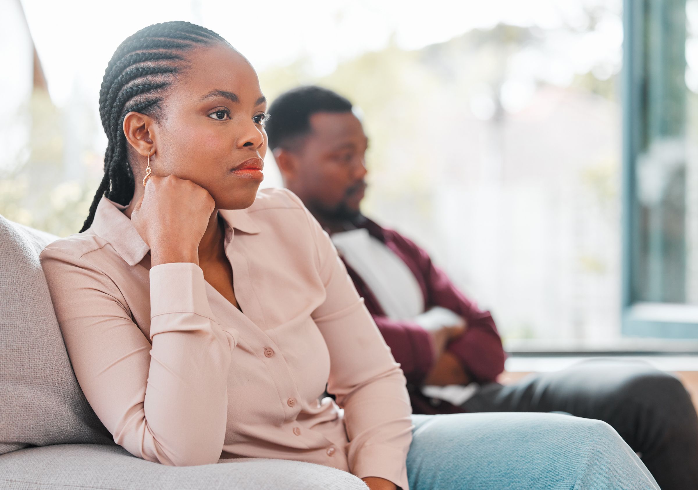 A couple sitting apart on a sofa after a disagreement