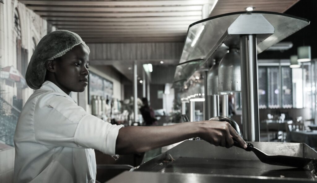 A chef at work at a grill in a commercial kitchen in Kempton Park
