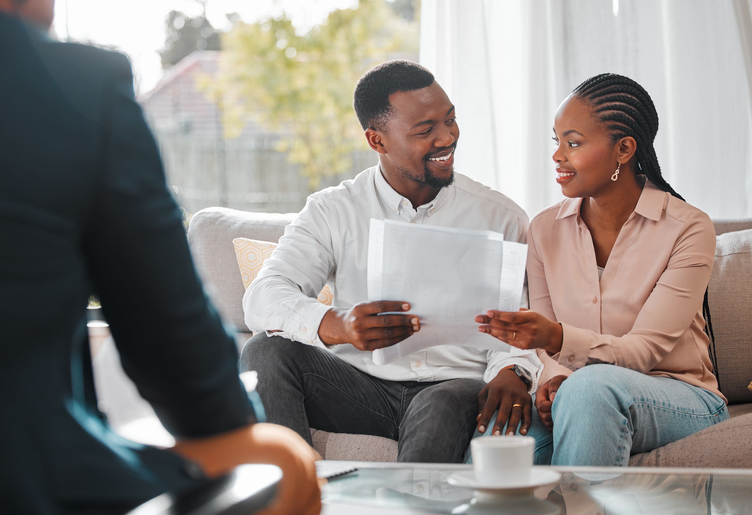 A couple reviewing property documents at home with an adviser